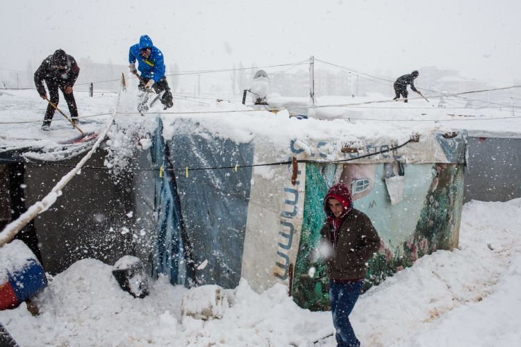 A refugee family's tent collapses under the weight of snow