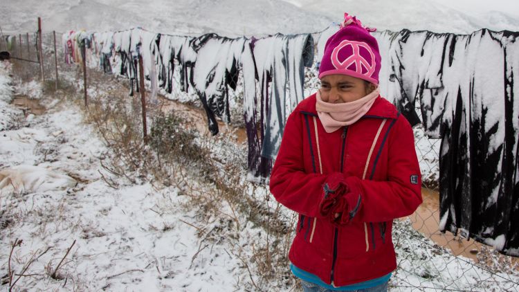 A Syrian refugee girl in Lebanon shivers in the cold