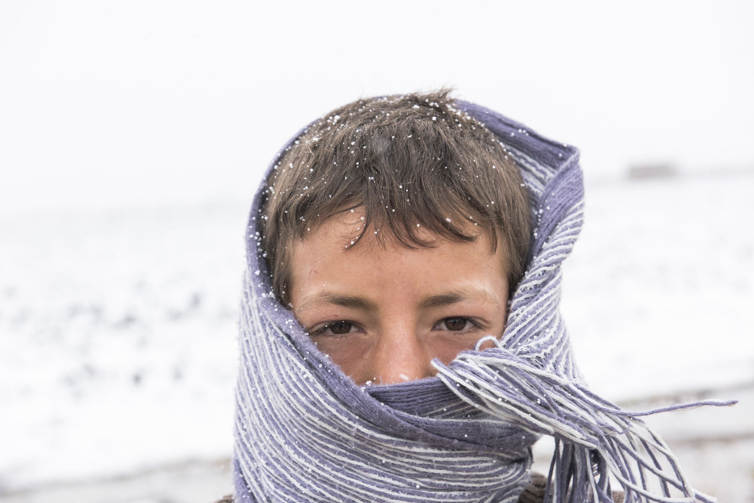 Syrian refugee boy standing in the snow
